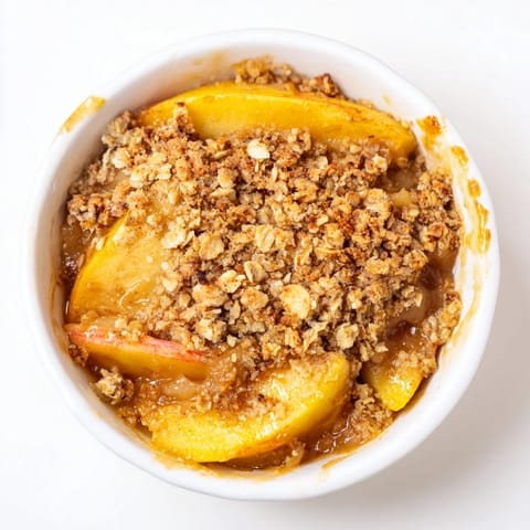 Golden baked Apple Crumble with a crunchy oat topping and warm cinnamon-spiced apples bubbling in a dish.
