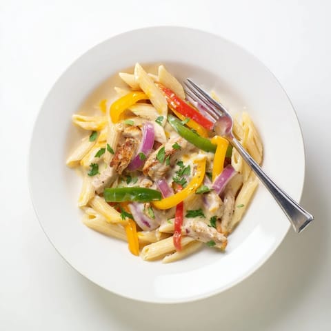In a deep skillet, tender fajita-spiced chicken strips mingle with sautéed red, yellow, and green bell peppers and onions in a creamy cheddar-mozzarella sauce, all tossed with perfectly cooked penne pasta.  