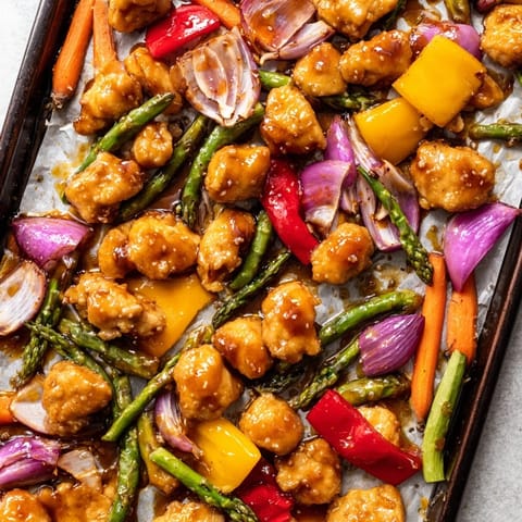 Tender bite-sized chicken and crisp asparagus with bell peppers, finished with fresh parsley and sesame seeds for a colorful weeknight meal.  