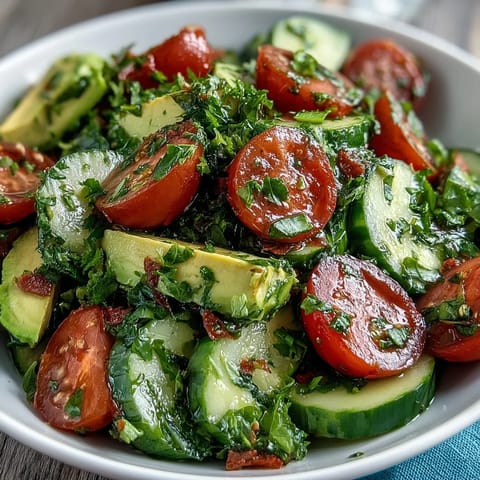 Fresh cucumber tomato avocado salad with lemon dressing, a vibrant mix of crisp veggies and creamy avocado in zesty citrus vinaigrette.