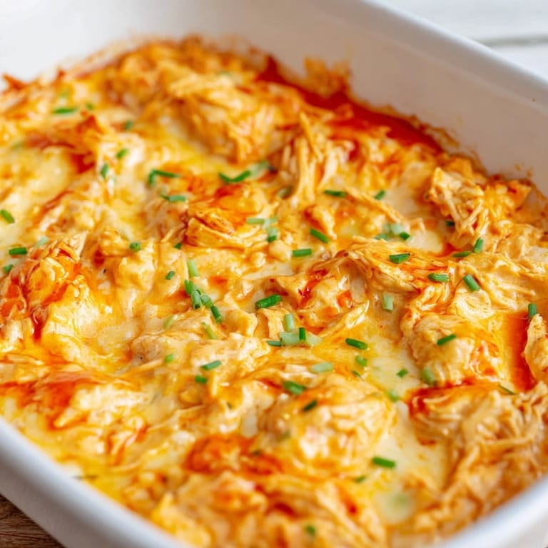 Creamy and spicy Buffalo Chicken Dip served with celery sticks and crunchy tortilla chips for dipping.