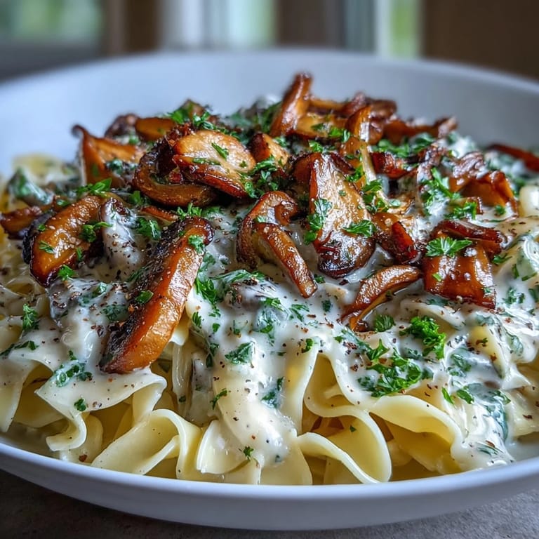 Close-up of Creamy Mushroom Stroganoff featuring sautéed mushrooms and creamy sauce in a cast-iron skillet.